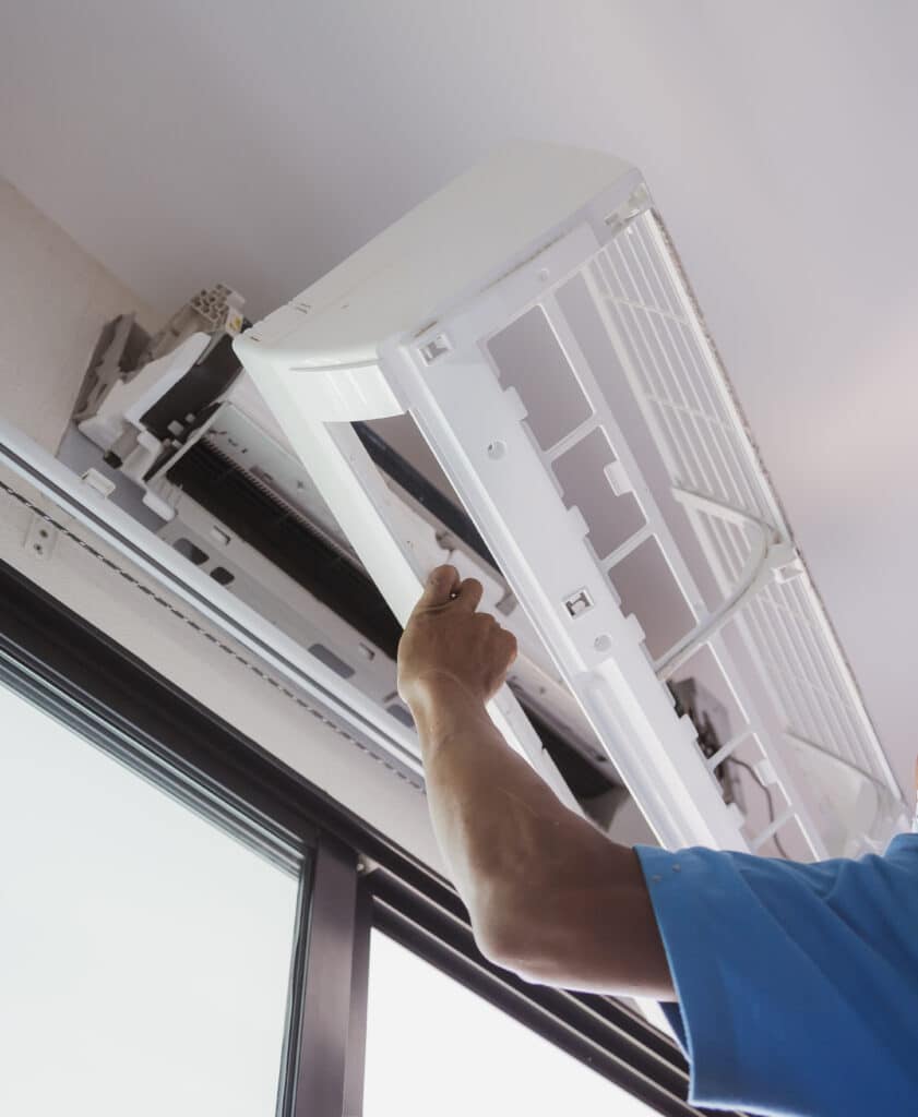 Technician electric cleaning home air conditioner indoors.