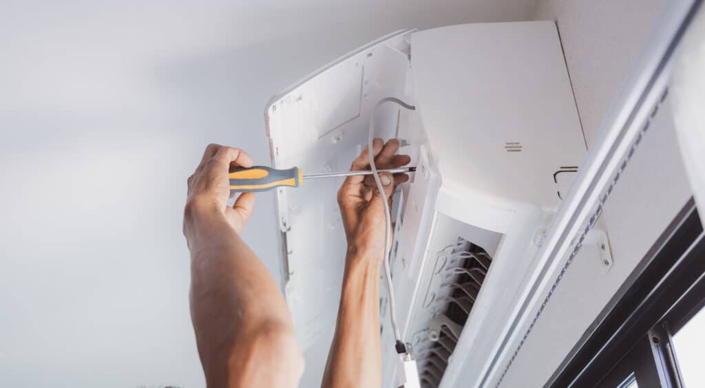 Technician electric cleaning home air conditioner indoors.